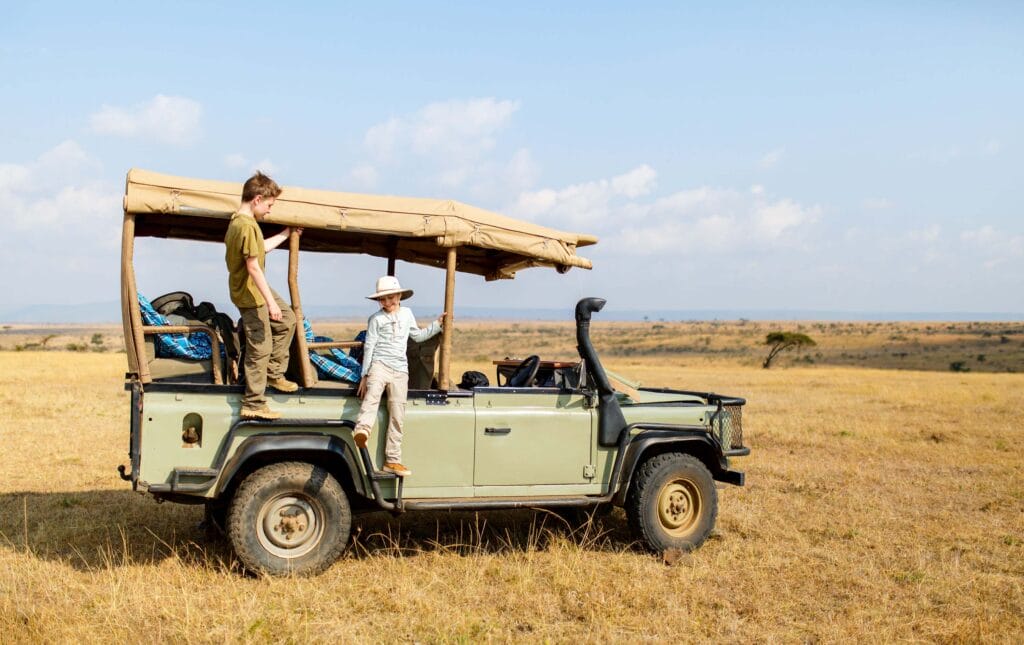 Kids on game drive in open vehicle enjoying safari